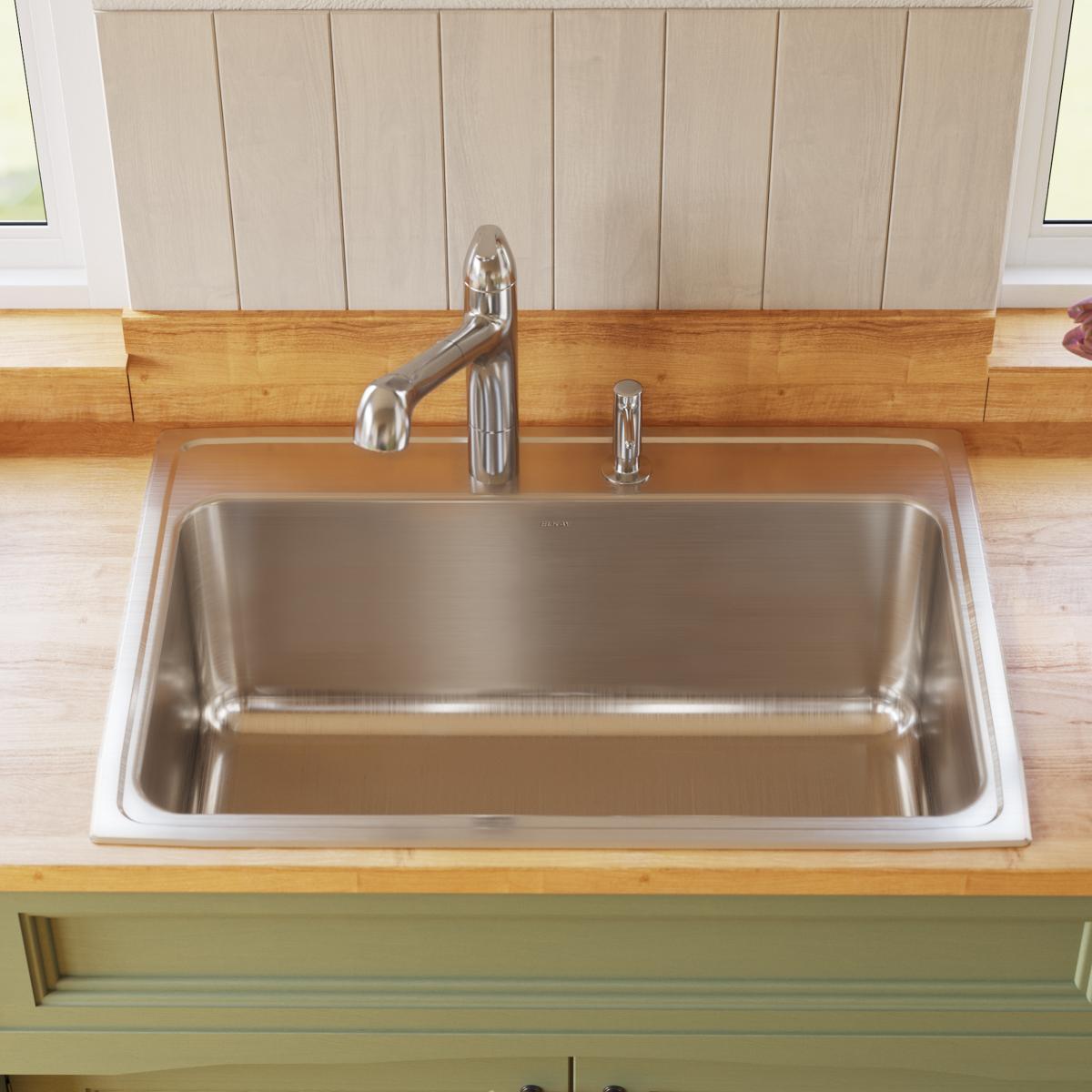 Stainless steel drop-in sink with single bowl, chrome faucet, and soap dispenser mounted on wood countertop.