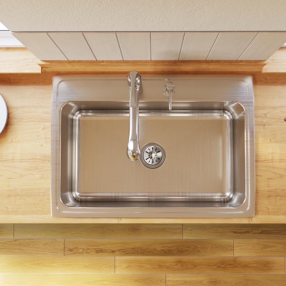 Stainless steel drop-in sink with single bowl, faucet, and drain strainer installed in wooden countertop, viewed from above.