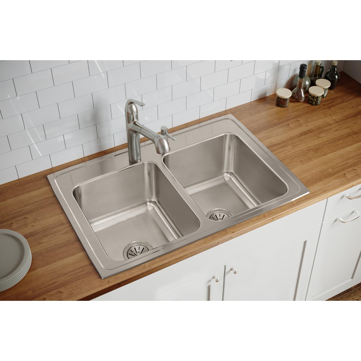 Stainless steel double bowl drop-in sink with two equal rectangular basins and single faucet installed in wooden countertop.