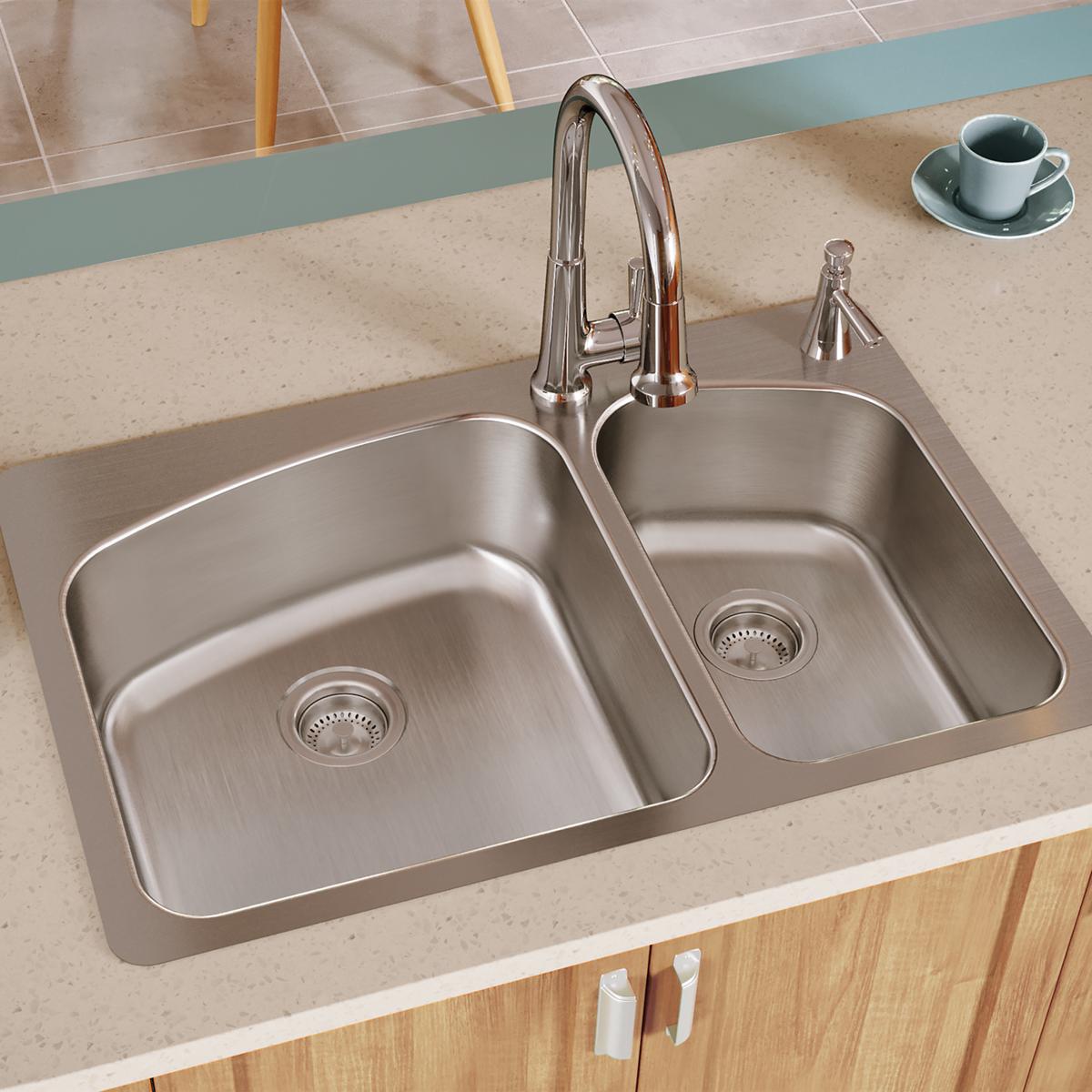 Stainless steel double bowl kitchen sink with chrome faucet and drain strainers installed in countertop.