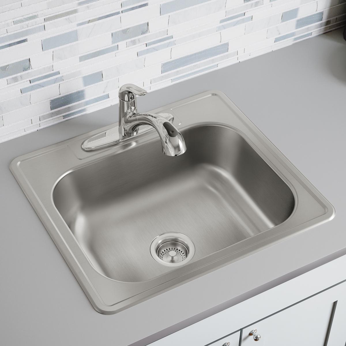 Stainless steel drop-in sink with single bowl, chrome faucet, and drain strainer installed in white countertop.