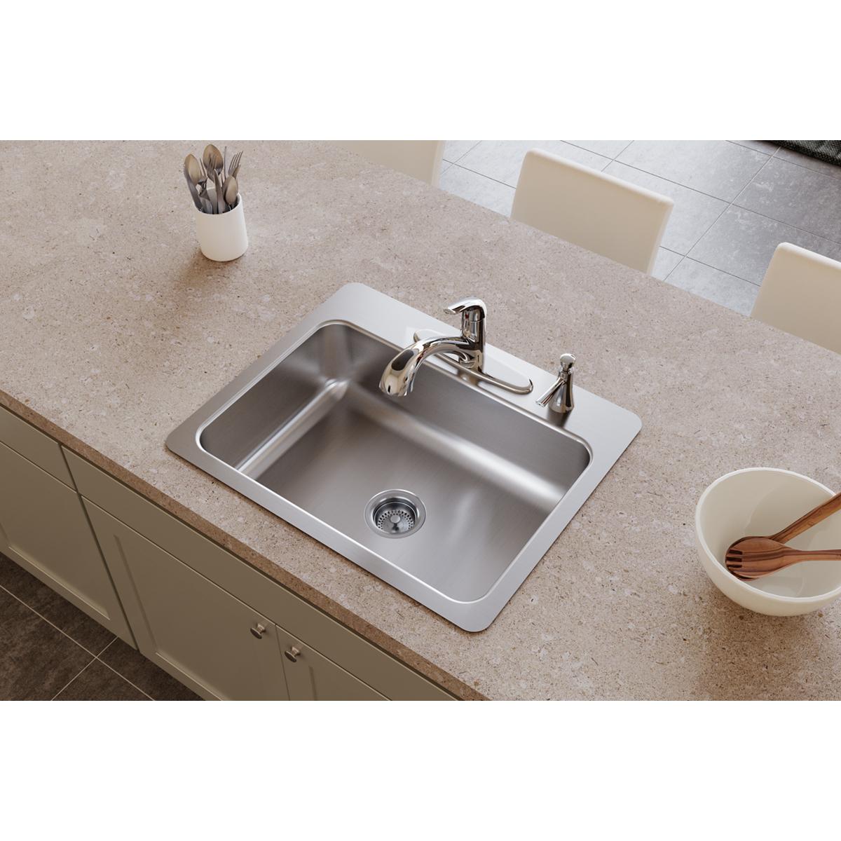 Stainless steel single bowl sink with two faucet holes mounted in countertop.