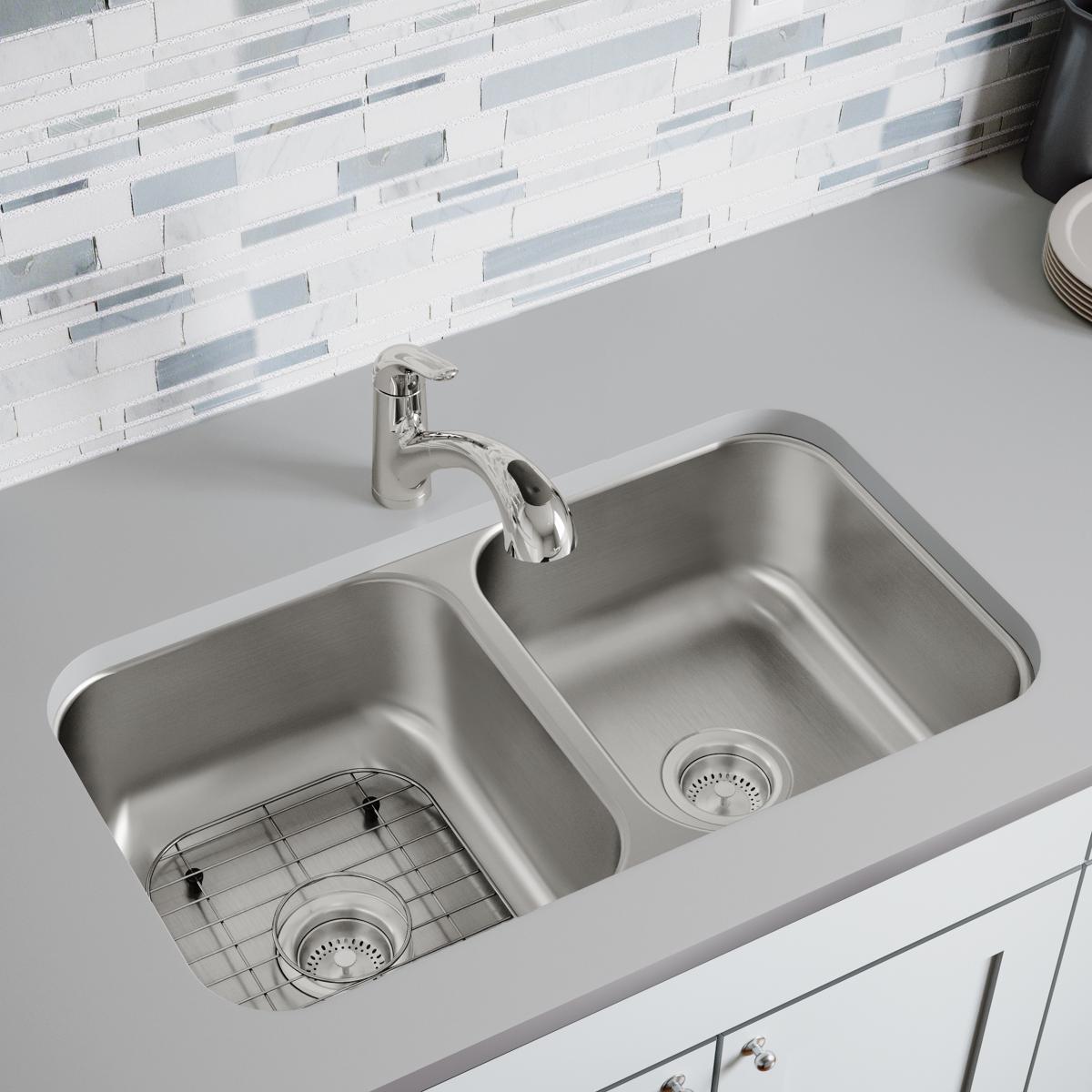 Stainless steel bottom grid with rectangular openings fitted in left compartment of double basin kitchen sink.