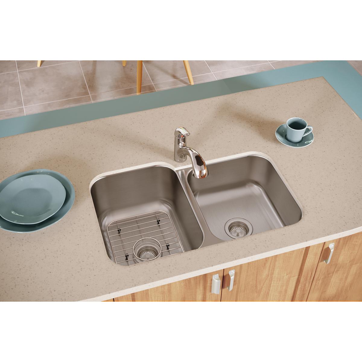 Stainless steel double bowl undermount sink with unequal 60/40 configuration, chrome faucet, and bottom grids installed in co