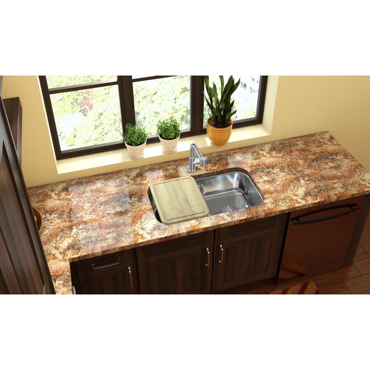Rectangular hardwood cutting board in light tan color positioned over a kitchen sink.