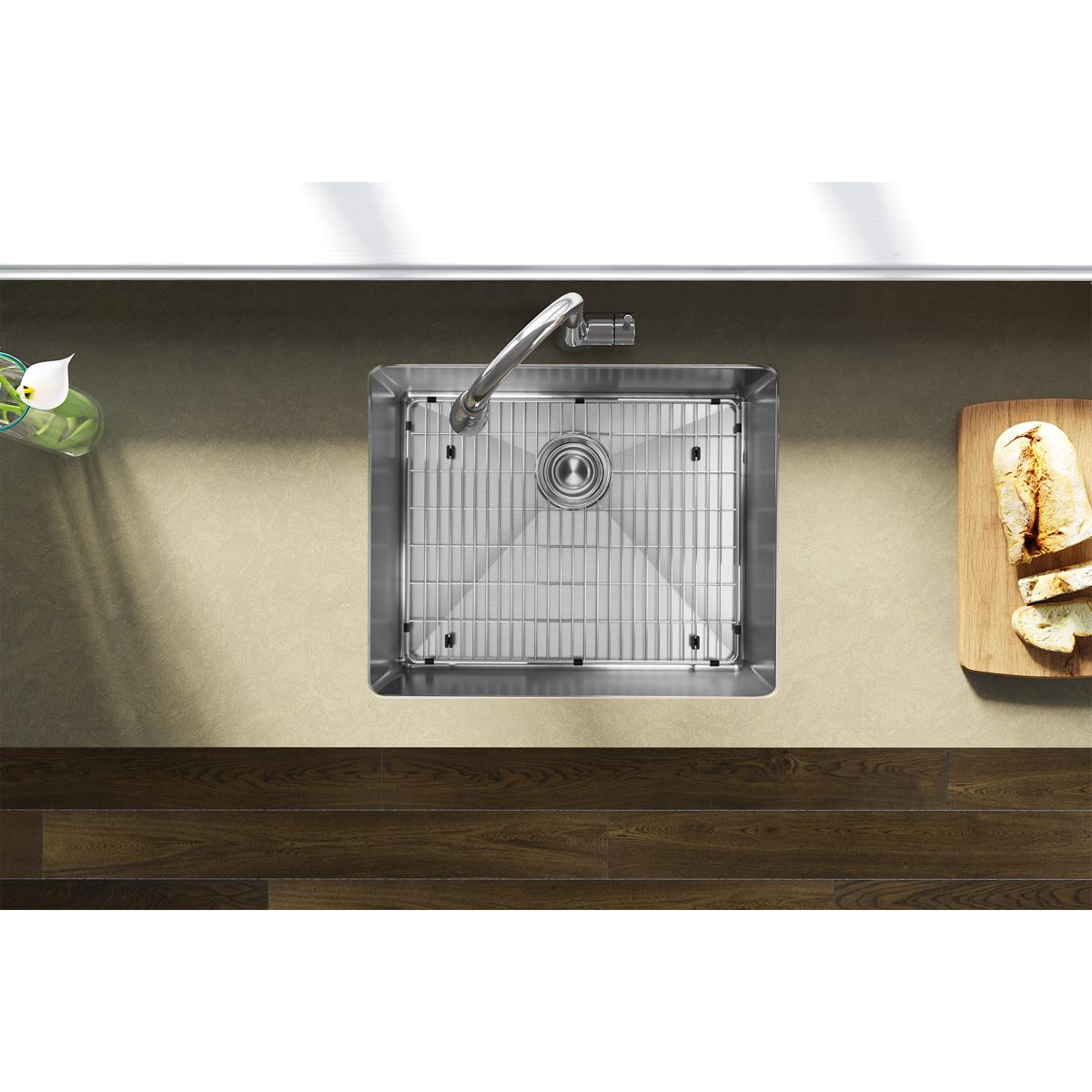 Stainless steel undermount sink with single bowl, drain strainer, and faucet installed in countertop, shown from above.