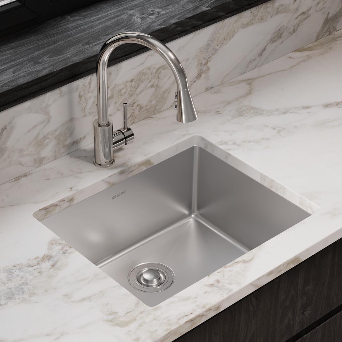 Stainless steel undermount sink with single bowl and matching pull-down faucet installed in marble countertop.