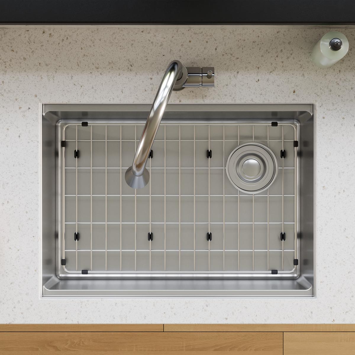 Stainless steel sink grid with vertical wire pattern and black corner brackets installed in undermount sink basin.