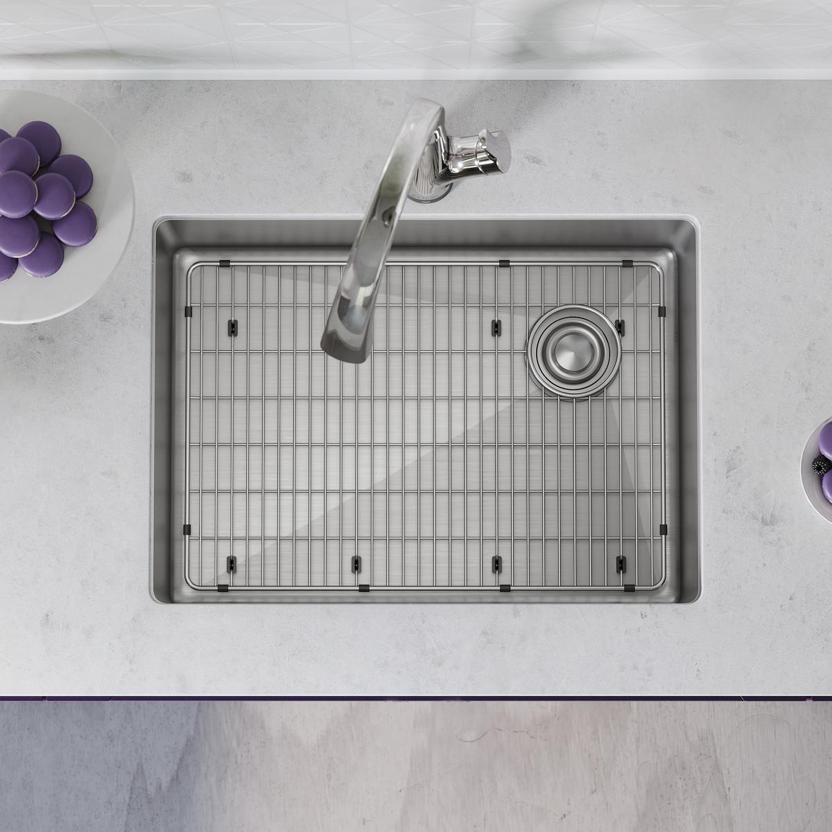 Stainless steel undermount sink with single bowl, metal grid strainer, and chrome filtered faucet installed in countertop.