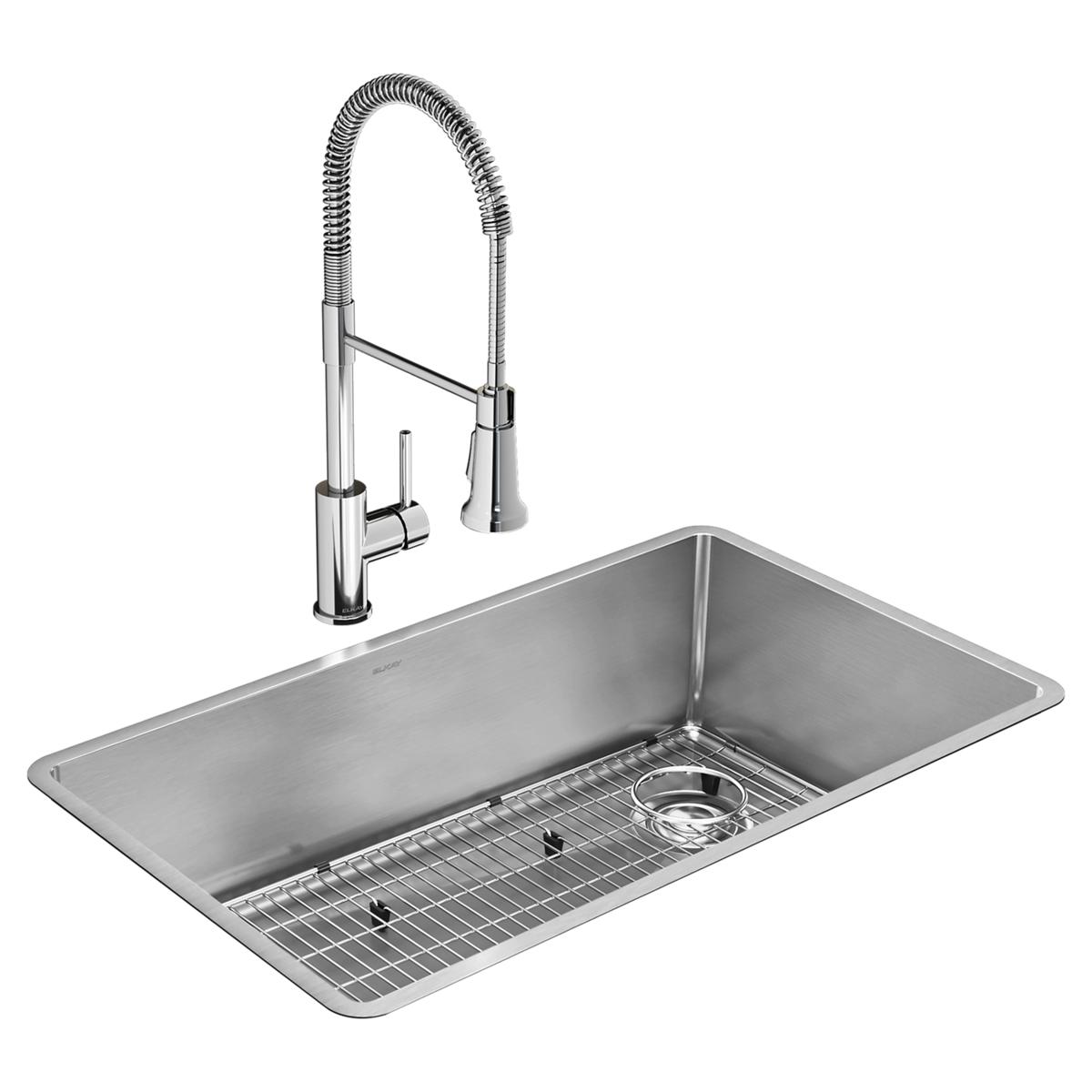 Stainless steel rectangular undermount sink with grid rack and chrome pull-down faucet with coiled hose.