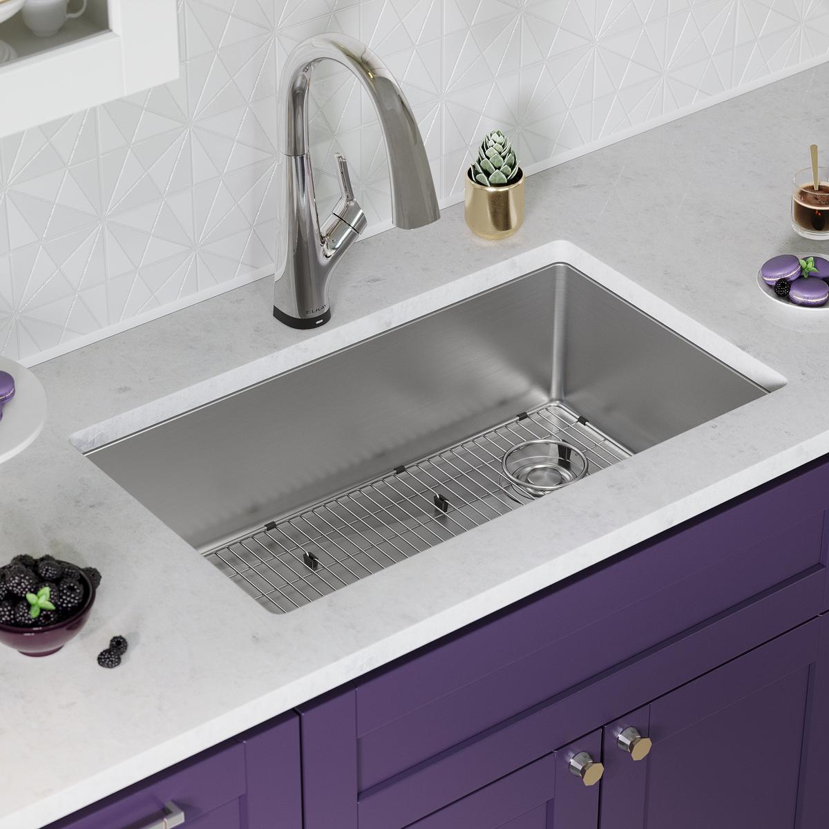 Stainless steel undermount sink bowl with single compartment, grid strainer, and arched pull-down faucet installed in white c