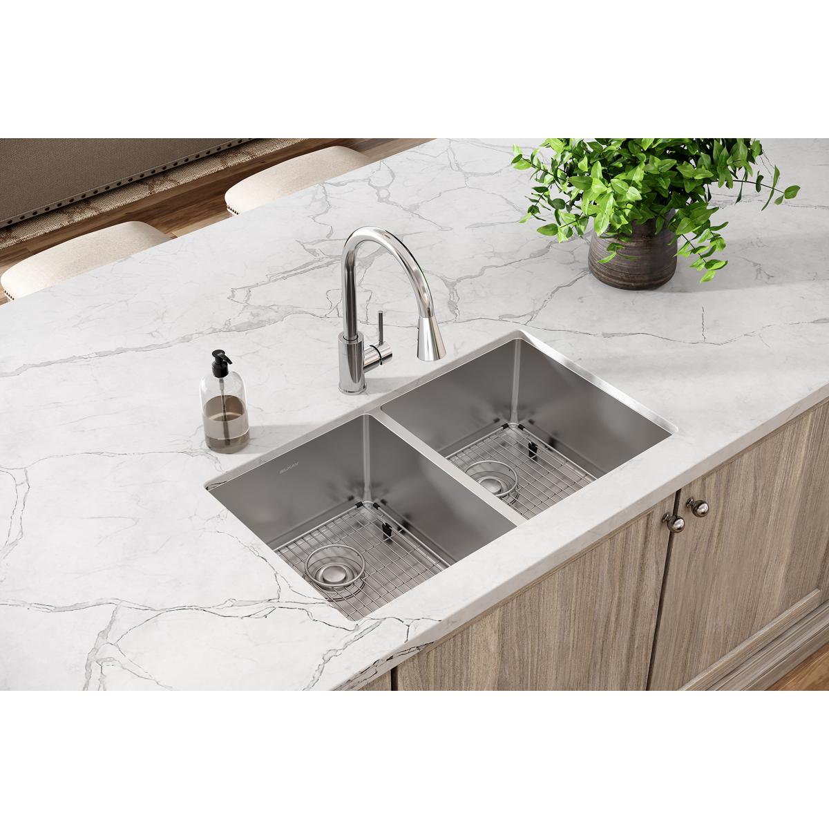 Stainless steel double bowl undermount sink with two equal compartments, grid inserts, and chrome pull-down faucet installed 