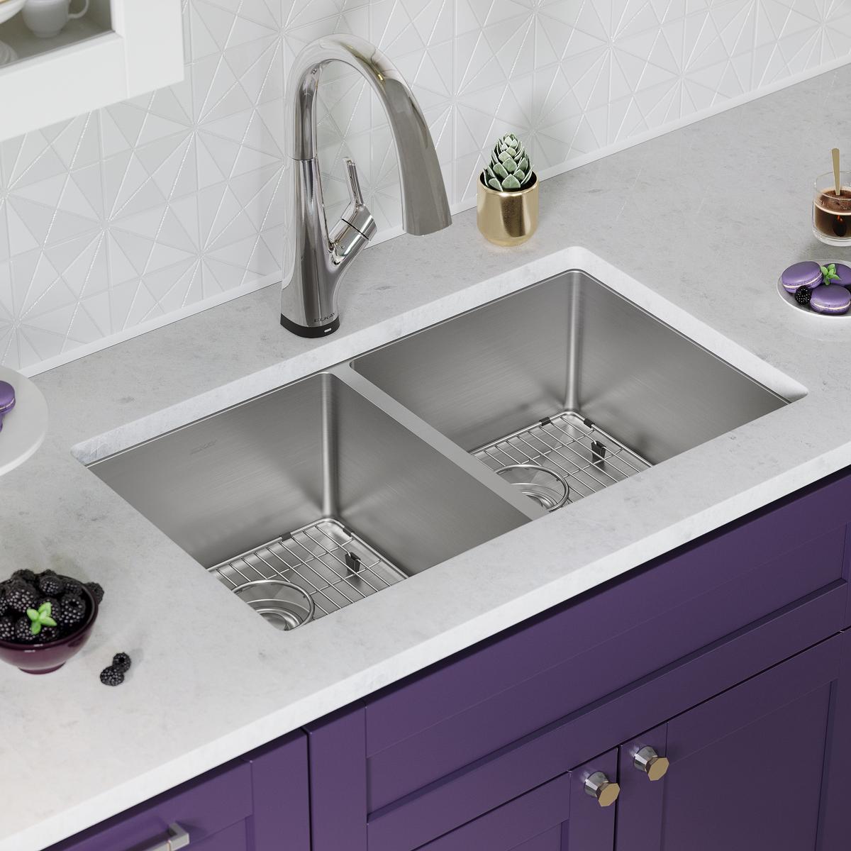 Stainless steel double bowl undermount sink with pull-down faucet installed in white countertop with purple cabinetry below.