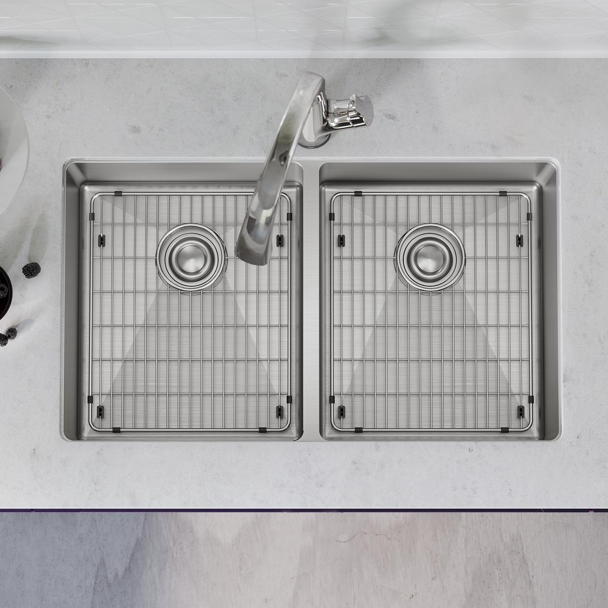 Stainless steel double bowl undermount sink with two equal compartments, grid inserts, and chrome filtered faucet mounted on 