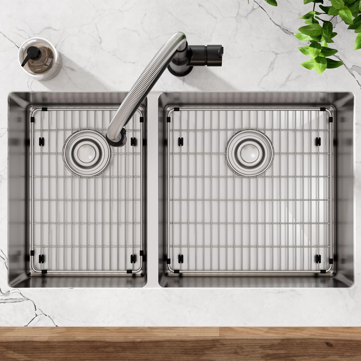Stainless steel double bowl undermount sink with grid inserts, drain strainers, and flexible hose viewed from above on marble
