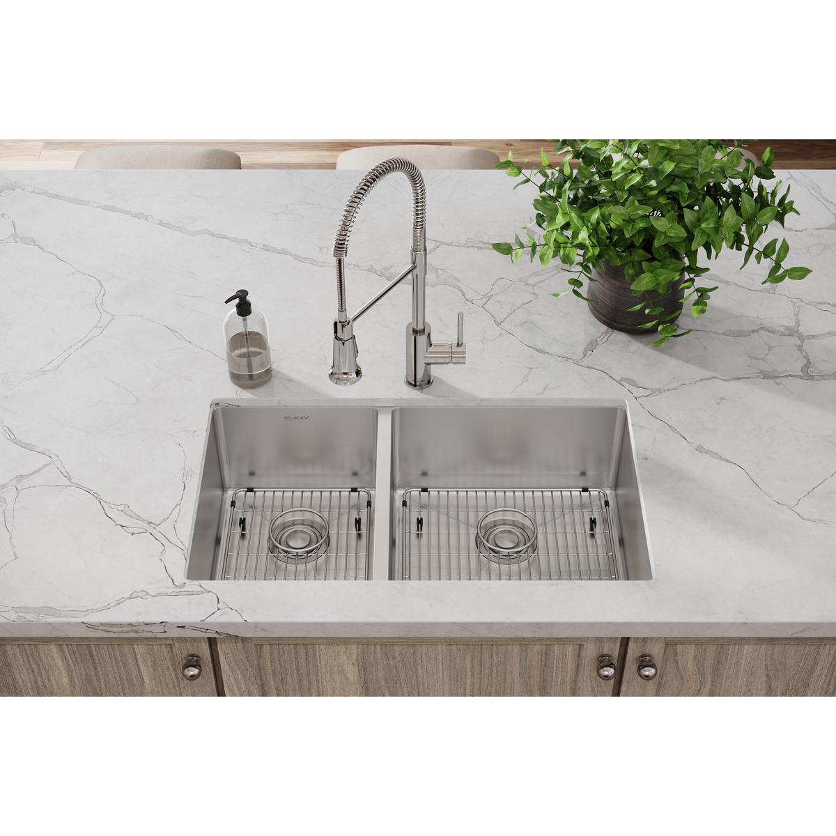 Stainless steel sink grid with parallel wire lines positioned in kitchen sink basin.