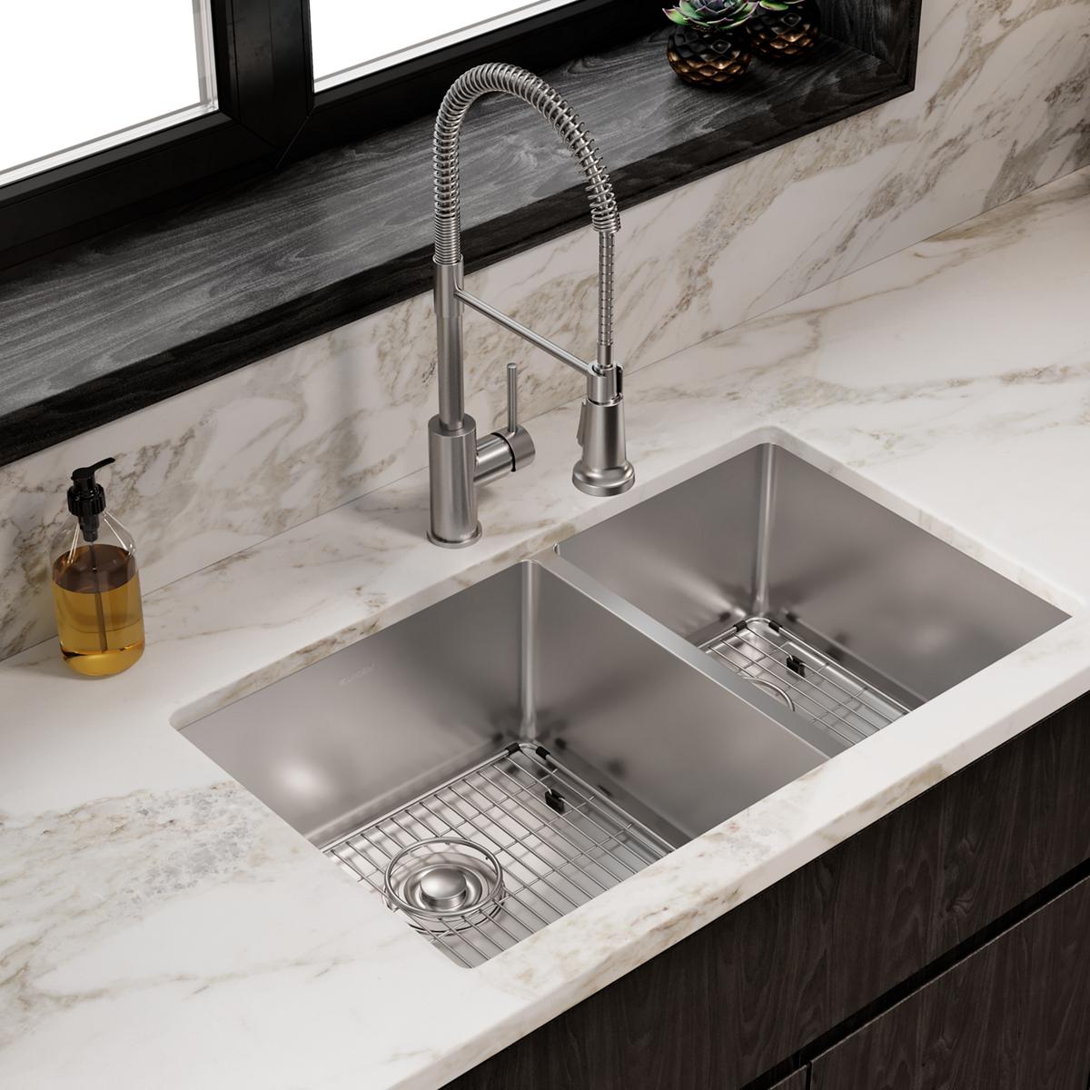 Stainless steel double bowl undermount sink with two compartments, grid inserts, and matching pull-down faucet installed in m