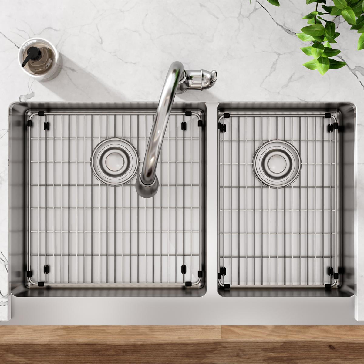 Stainless steel double bowl farmhouse sink with two grids, chrome faucet, and drain strainer viewed from above.