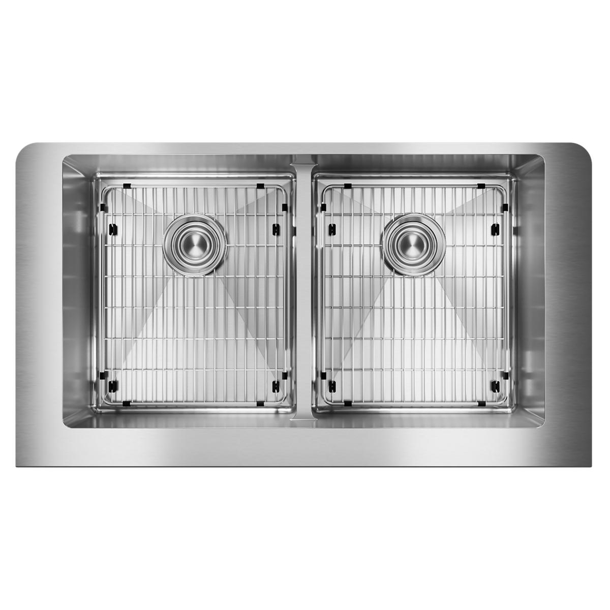 Stainless steel farmhouse sink with two equal bowls, each containing a strainer grid and drain, divided down the center.