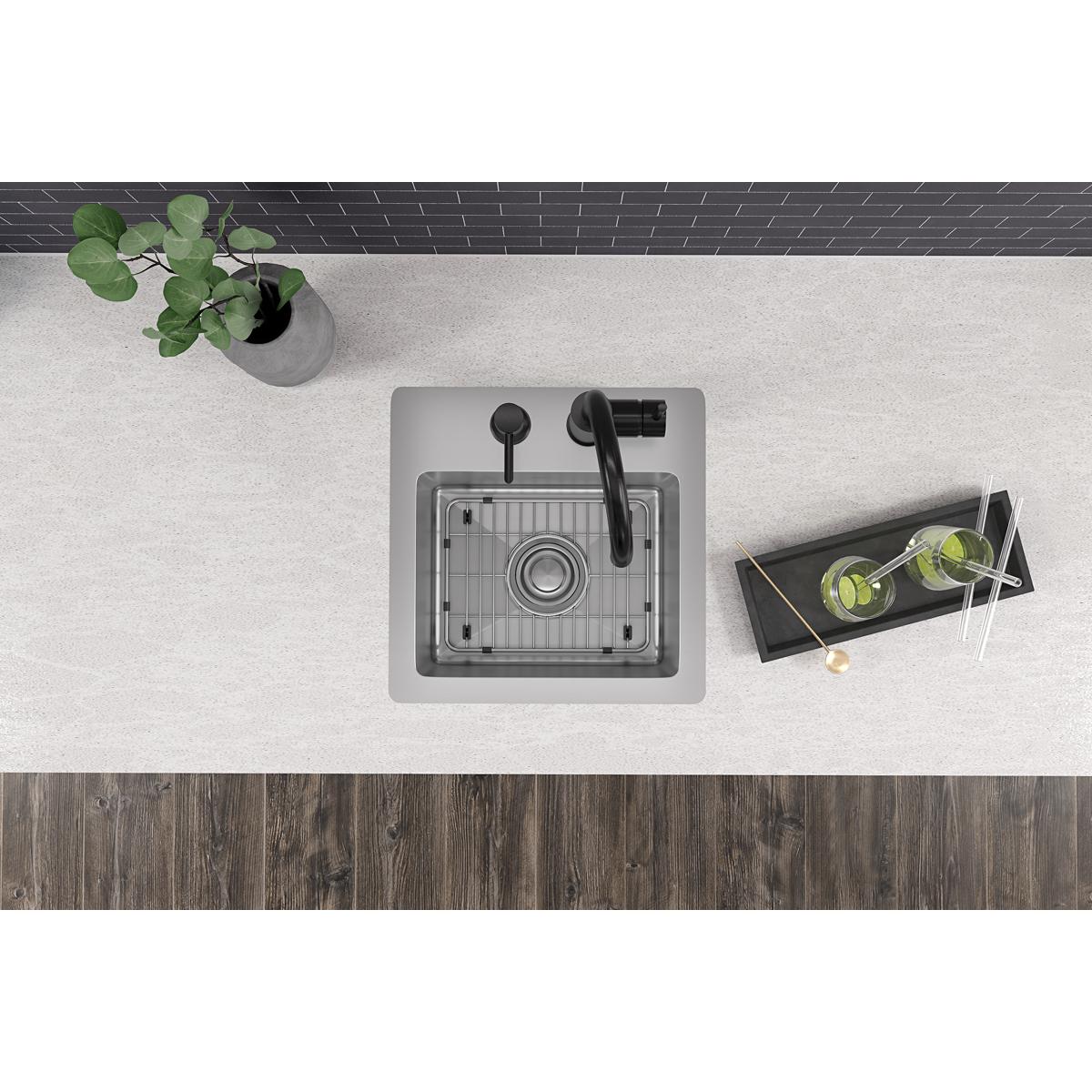 Stainless steel square bar sink with single bowl, two faucet holes, and integrated drain grid mounted in countertop.