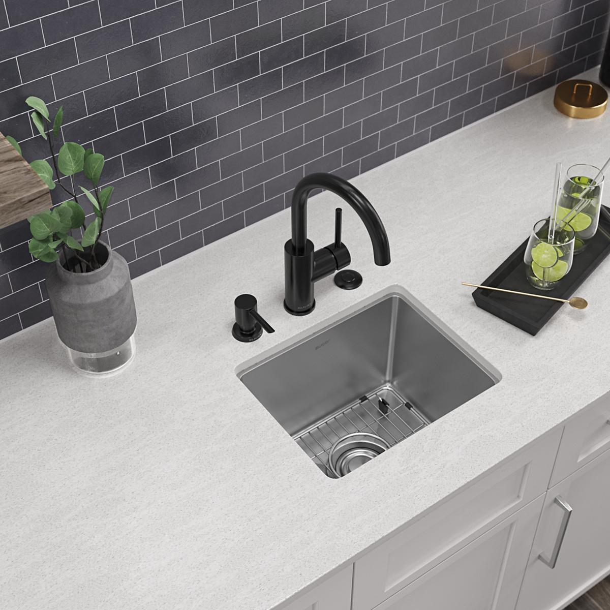 Stainless steel single bowl bar sink with three mounting holes, paired with black arc faucet and soap dispenser on white coun