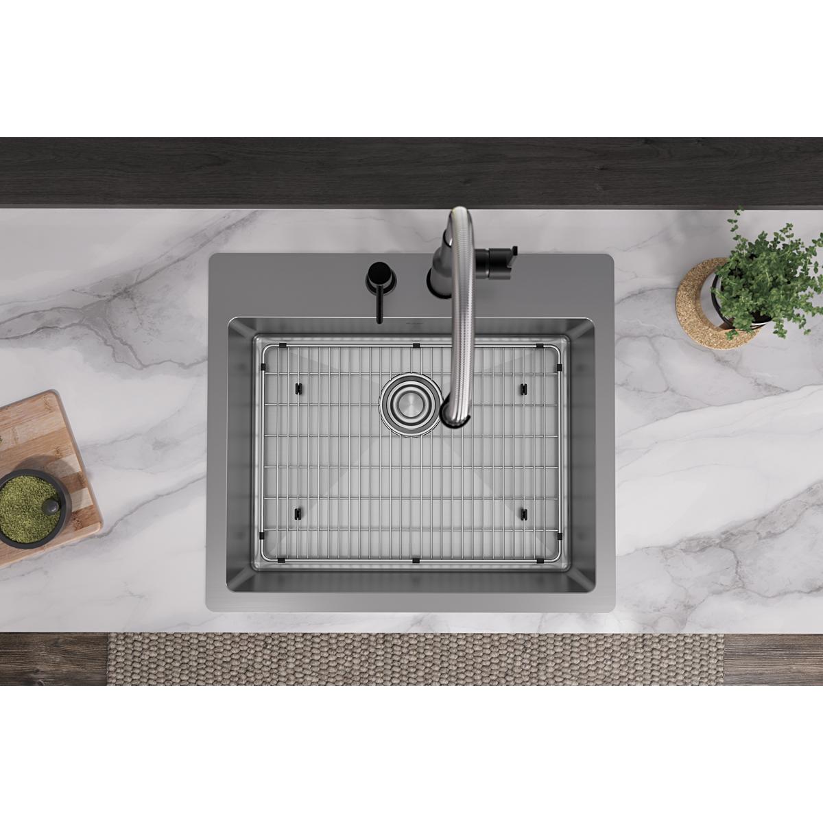 Stainless steel single bowl sink with grid and faucet mounted on marble countertop, overhead view.
