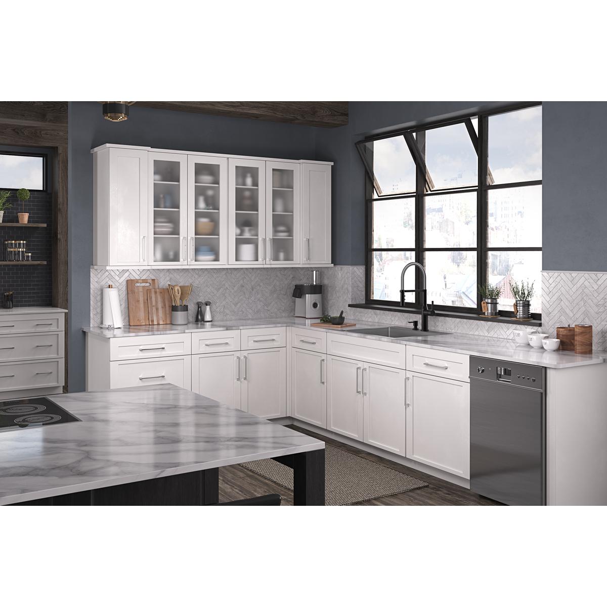 Stainless steel single bowl kitchen sink with two faucet holes installed in white cabinetry countertop.