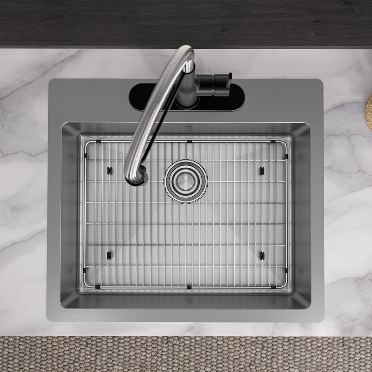Stainless steel single bowl sink with grid and drain strainer, viewed from above on marble countertop.