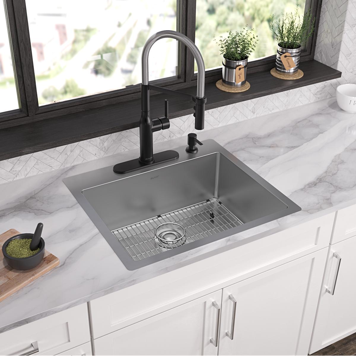 Stainless steel single bowl sink with four mounting holes, wire rack, and black pull-down faucet installed in white kitchen c