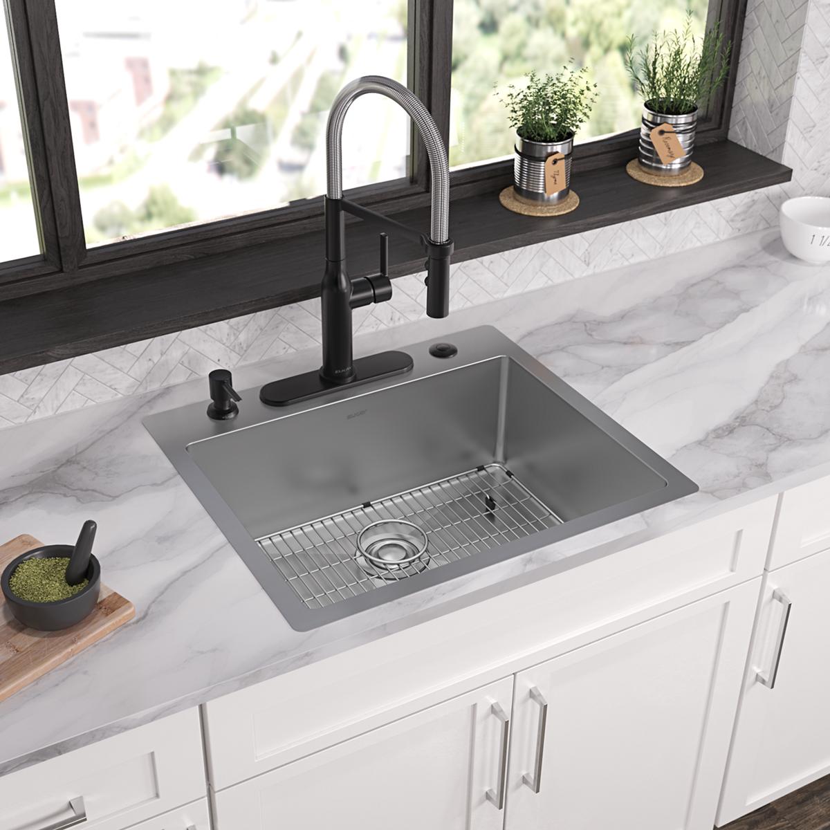 Stainless steel single bowl sink with five holes mounted in white countertop, featuring black pull-down faucet and grid inser