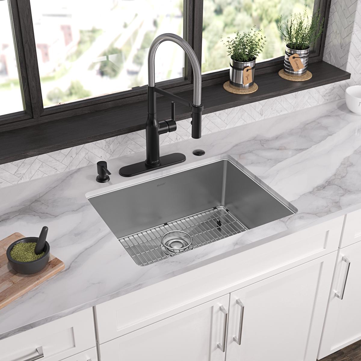 Stainless steel single bowl sink with black pull-down faucet, grid insert, and mounting hardware installed in marble countert