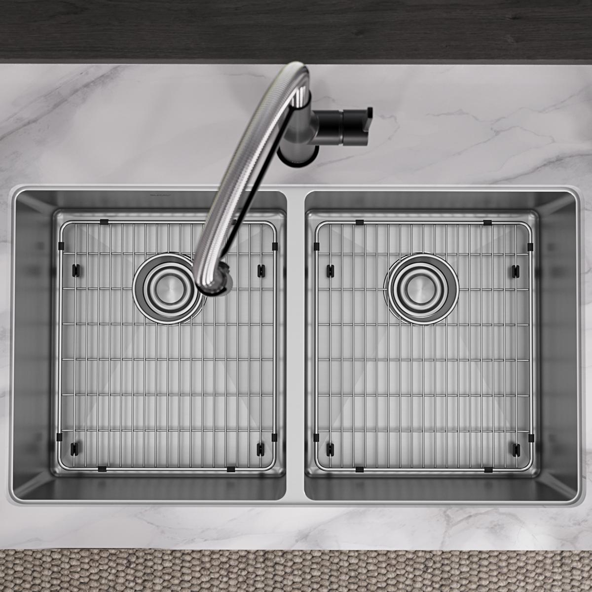 Stainless steel double bowl sink with two equal-sized basins, drain grids, and curved faucet, viewed from above on marble cou