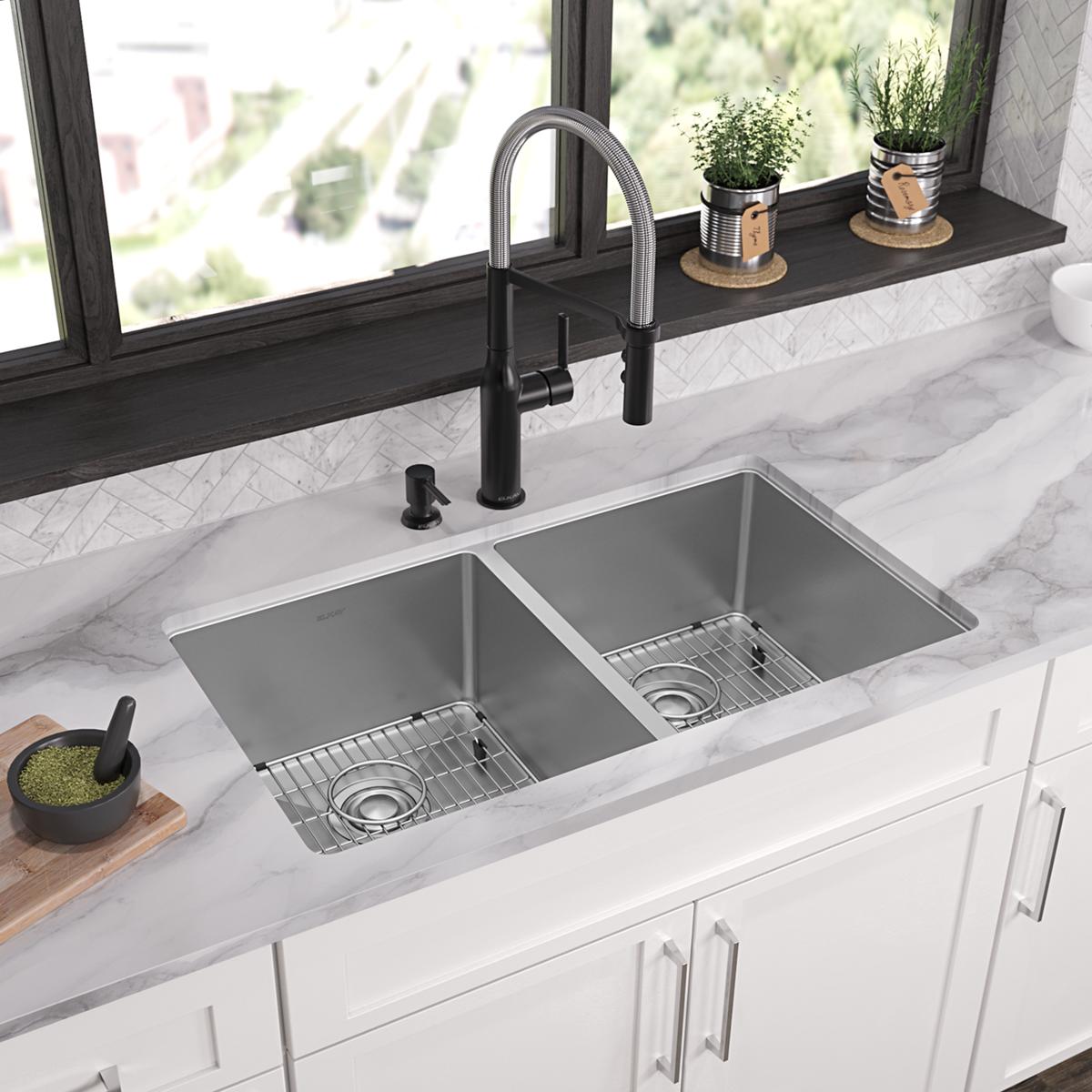 Stainless steel double bowl kitchen sink with two equal compartments, drain holes, and included grid inserts installed in whi