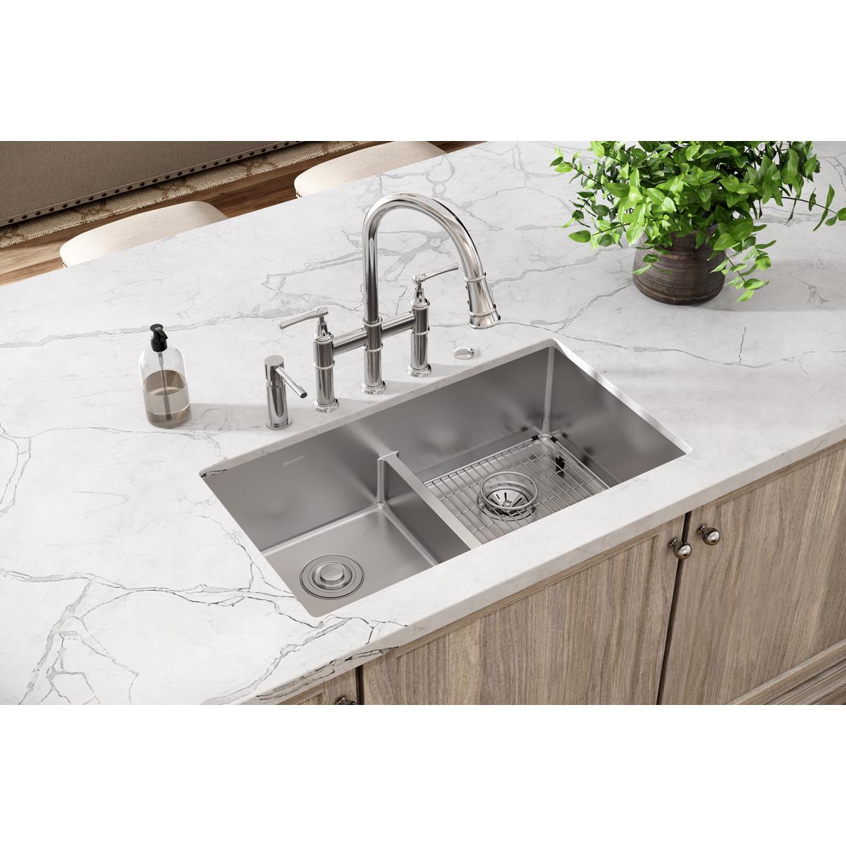 Stainless steel double bowl sink with divider, pull-down faucet, and five mounting holes installed in white marble countertop