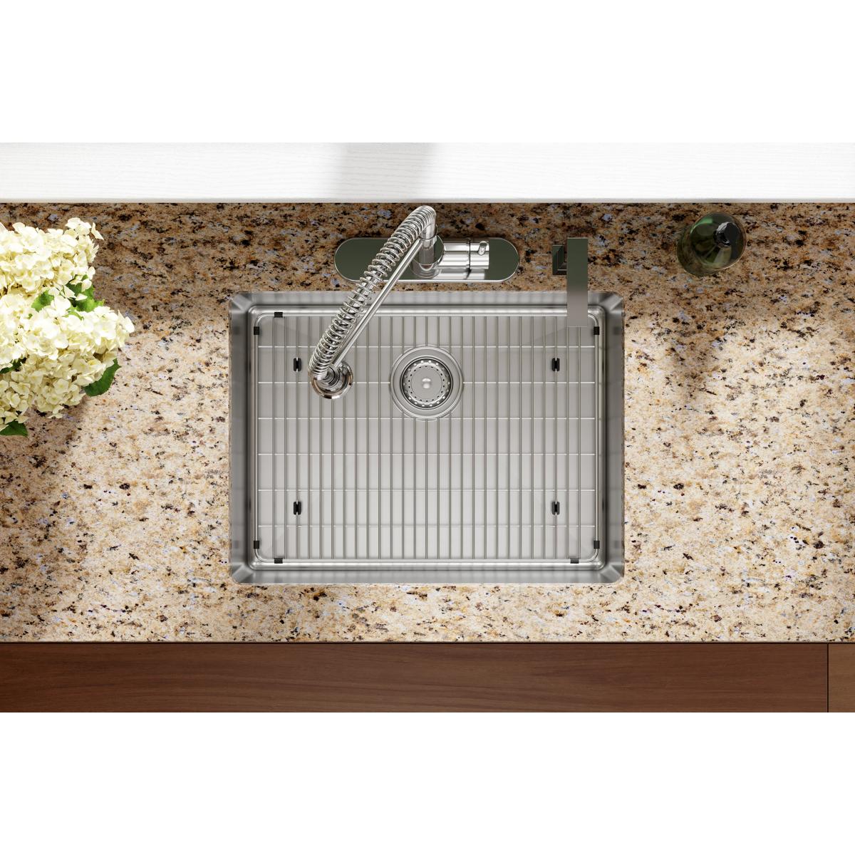 Stainless steel single bowl sink with vertical ridged basin, chrome faucet, and four mounting holes installed in speckled gra