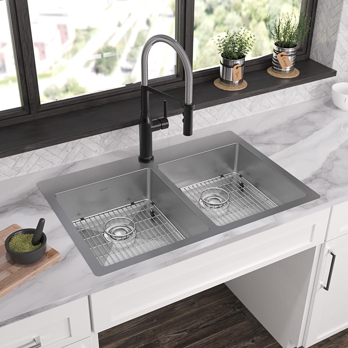 Stainless steel double bowl kitchen sink with two equal compartments, metal strainers, and black pull-down faucet installed i