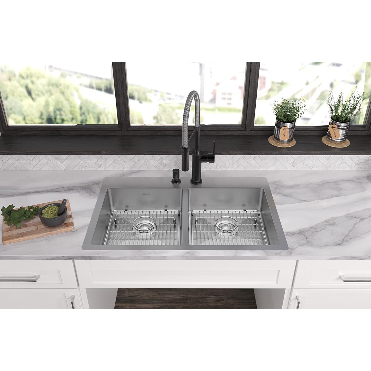 Stainless steel double bowl sink with two drain holes and matching faucet installed in white countertop with grid strainers v
