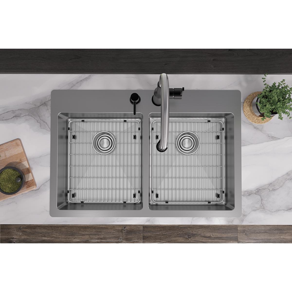 Stainless steel dual bowl sink with two holes, grid inserts, and faucet installed in marble countertop.