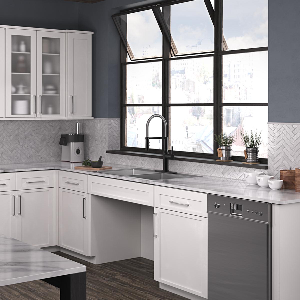 Stainless steel double bowl sink with two equal-sized basins mounted in white kitchen cabinetry beneath a window.