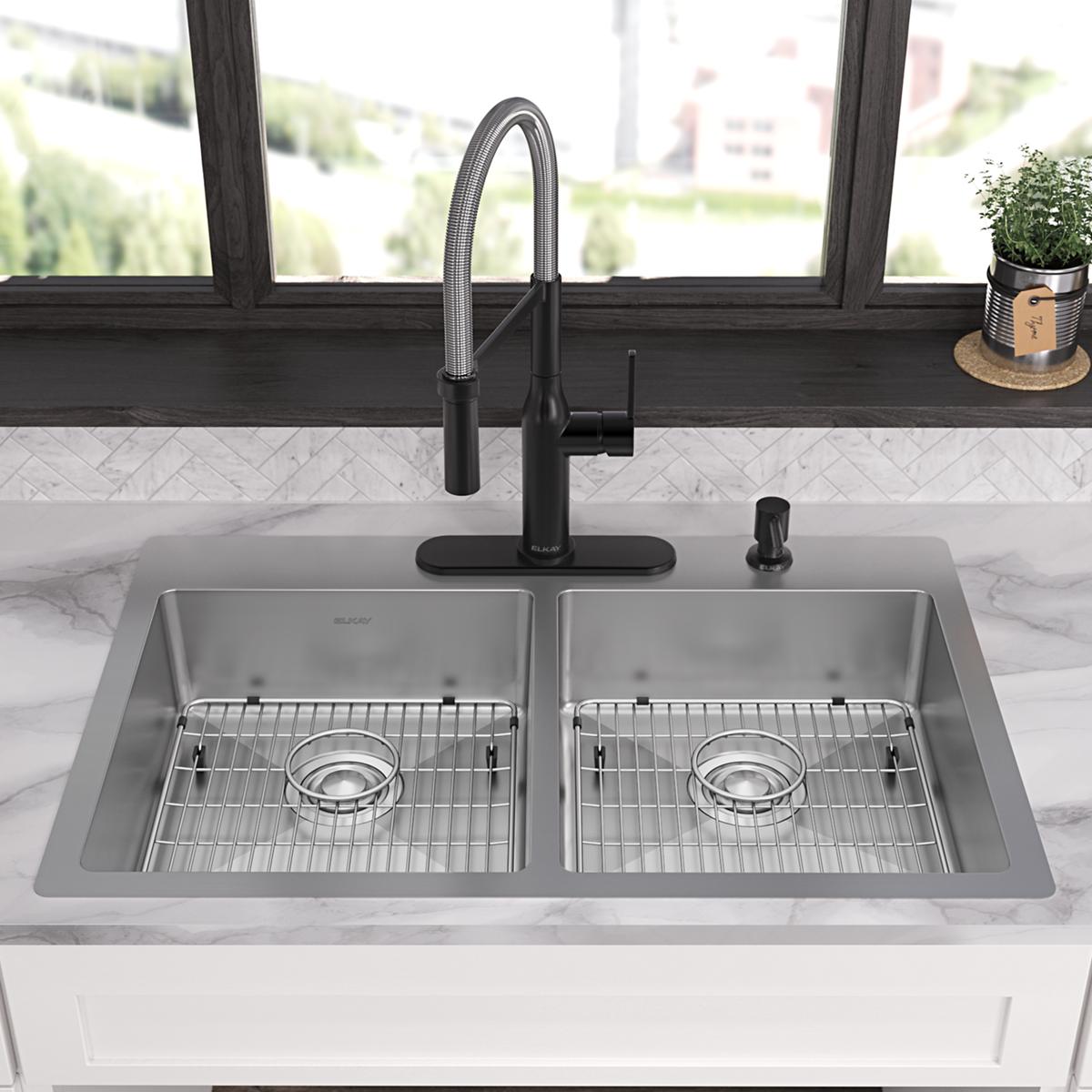Stainless steel double bowl sink with two equal basins, grid inserts, black pull-down faucet, and soap dispenser mounted on m
