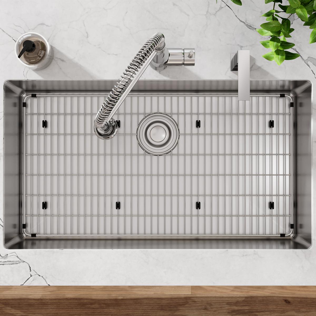 Stainless steel single bowl sink with grid, spiral faucet, and two mounting holes, viewed from above.