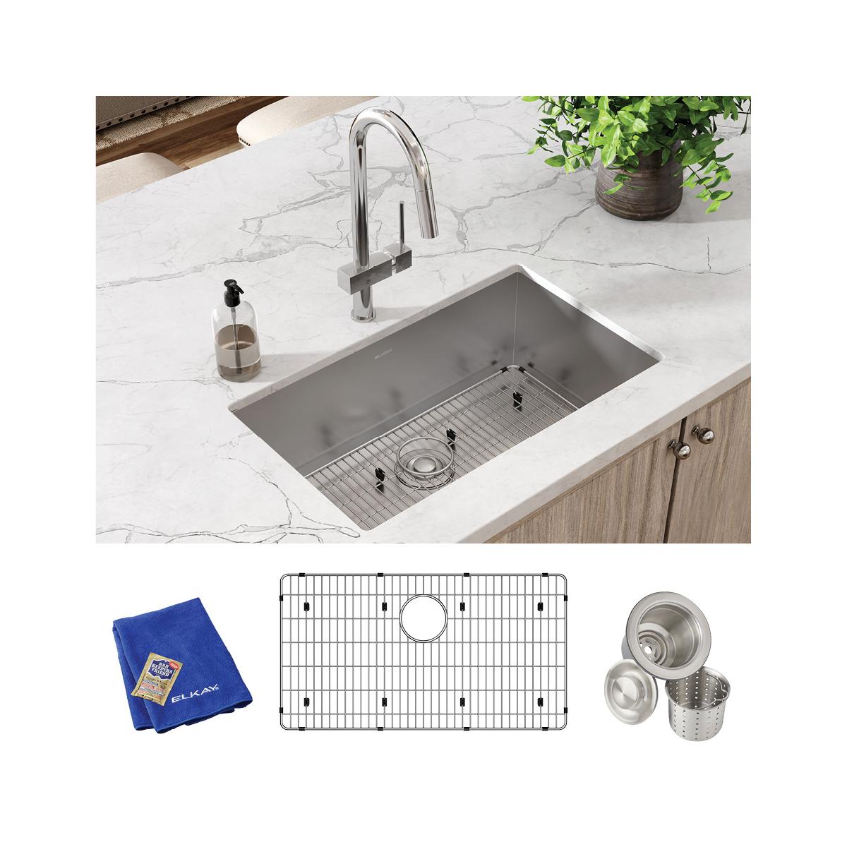 Stainless steel undermount sink with rounded corners installed in white marble countertop, includes grid, strainer baskets, a
