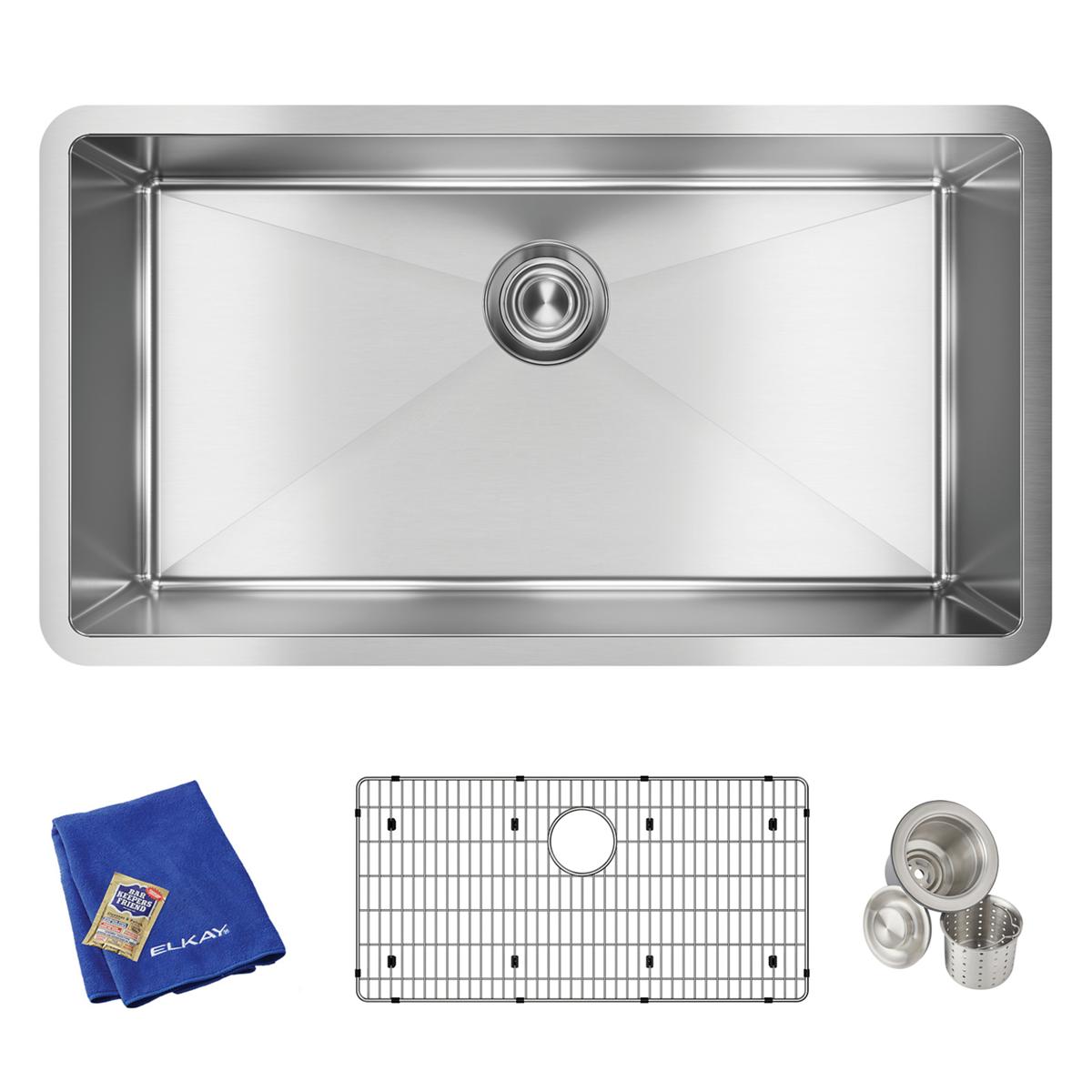 Stainless steel single bowl undermount sink with drain opening, shown with grid strainer, basket strainers, and blue cloth.