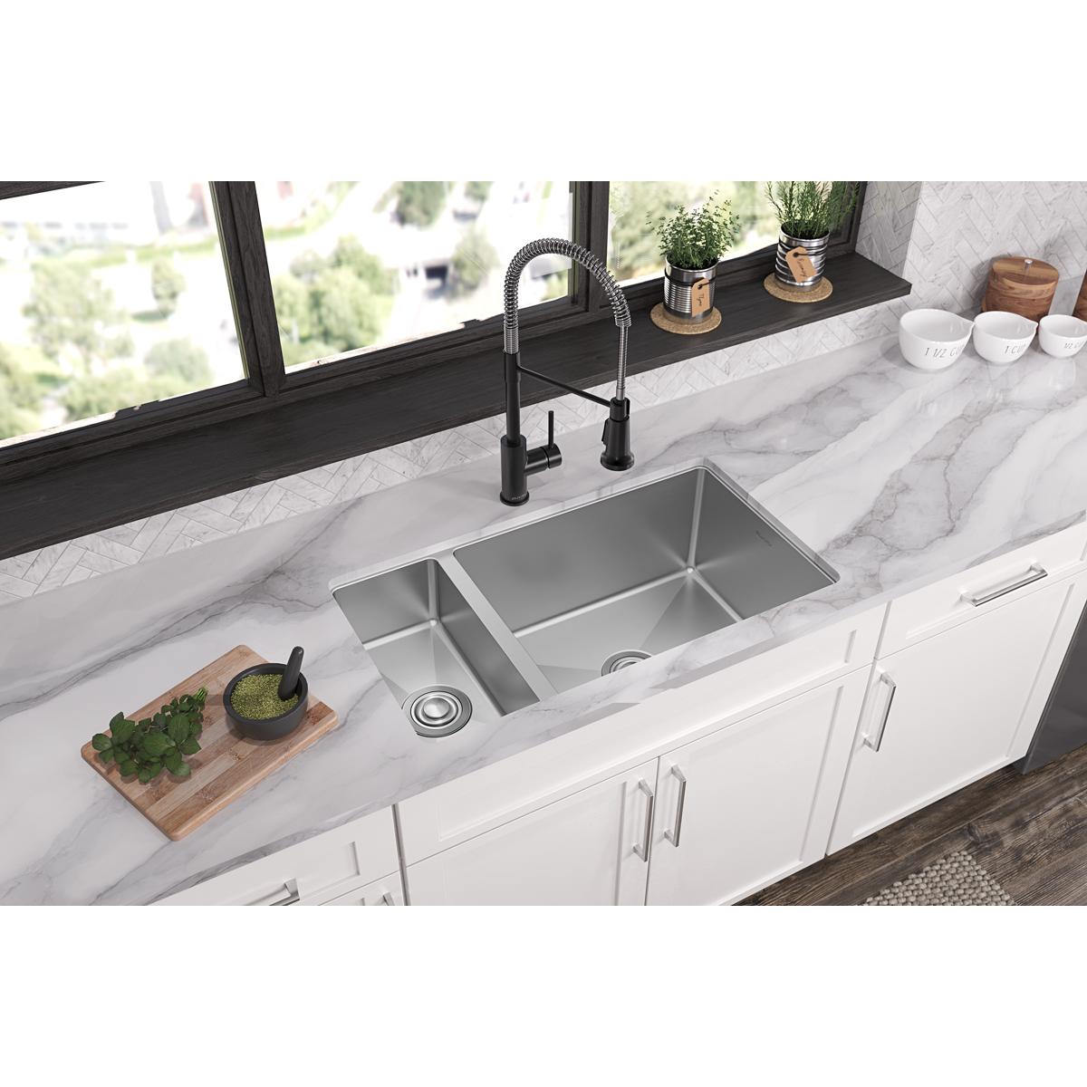 Stainless steel double bowl undermount sink installed in white countertop with black faucet and drain.