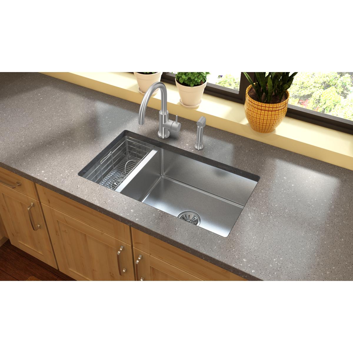 Satin stainless steel kitchen faucet with curved spout, lever handle, and detachable side spray installed above undermount do
