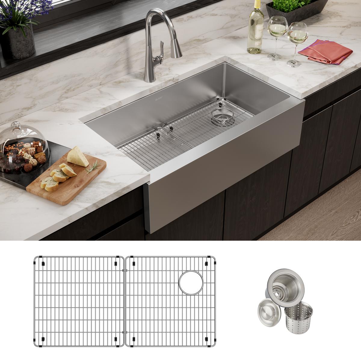 Stainless steel single bowl farmhouse sink installed in marble countertop with faucet, grid, and strainer accessories shown.