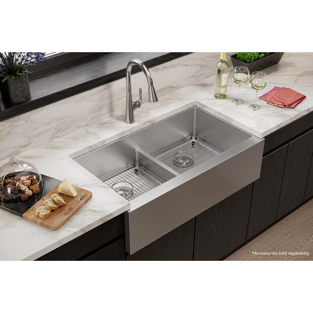 Stainless steel double bowl farmhouse sink with equal-sized basins, divider, and grid inserts installed in marble countertop.