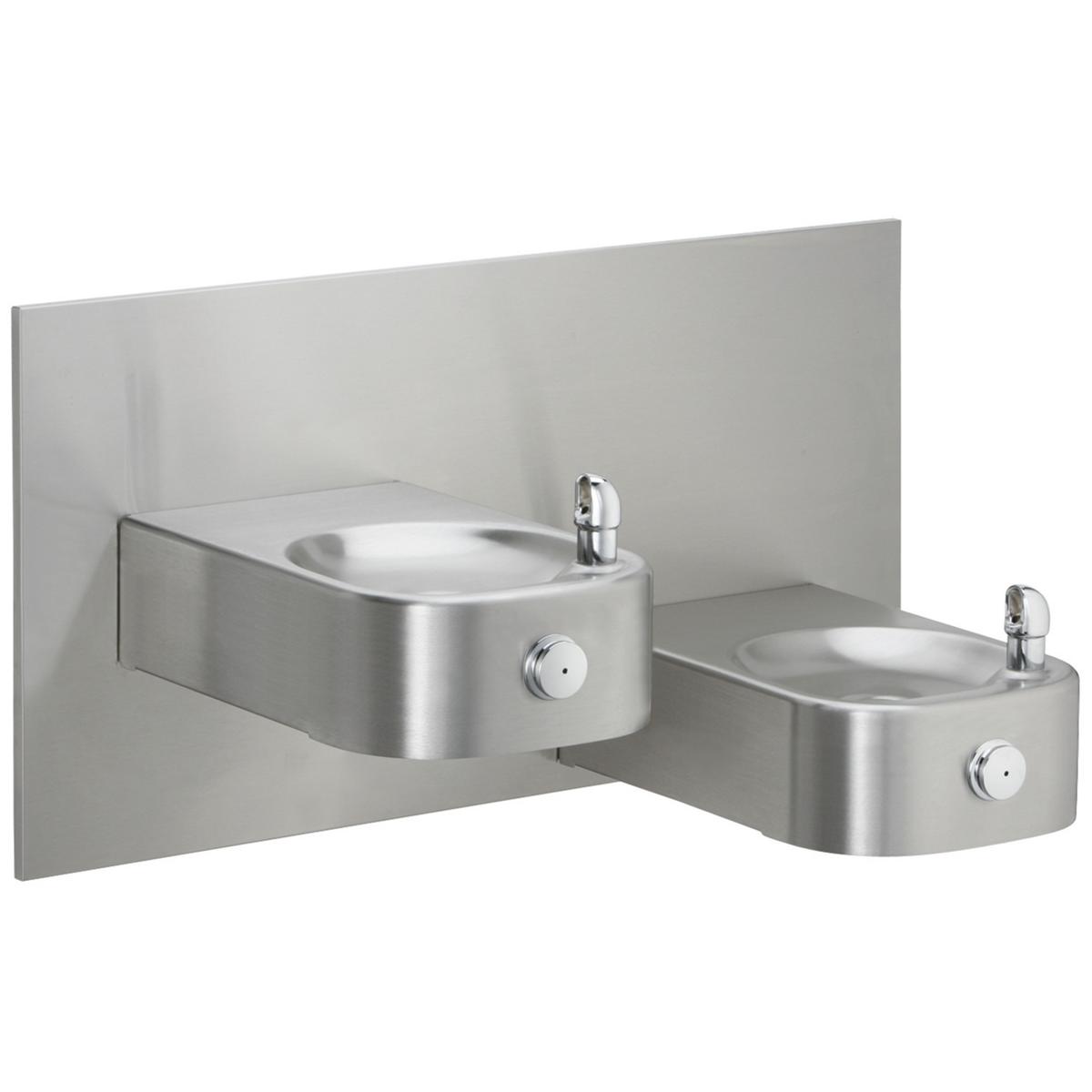 Stainless steel bi-level drinking fountain with two oval basins mounted on gray panel with chrome faucets.