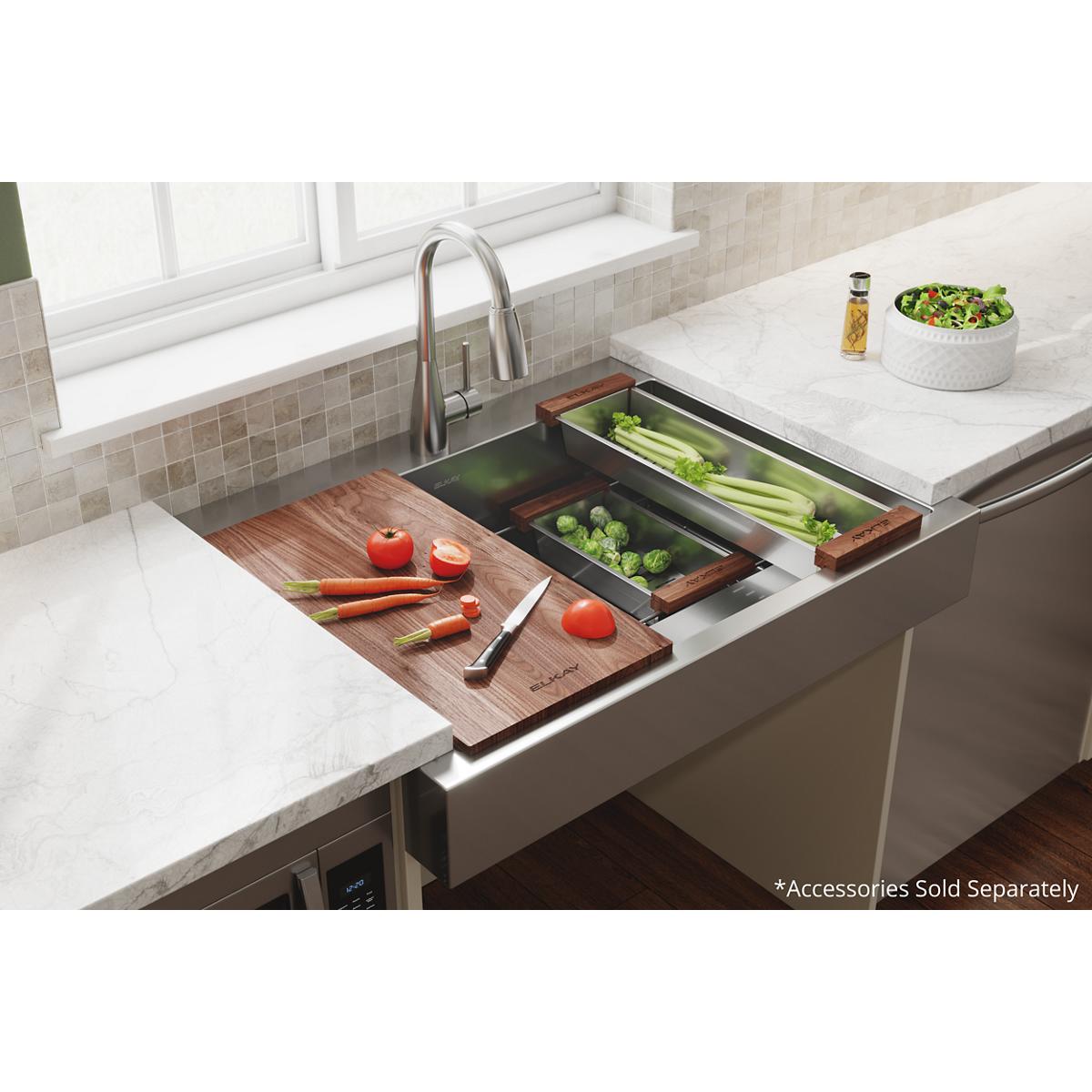 Brown hardwood cutting board with vegetables and knife on kitchen sink counter.