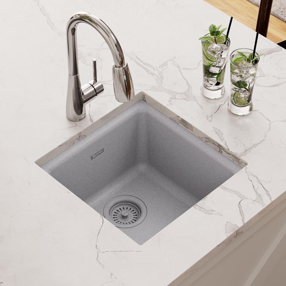 Greystone quartz square bar sink with single bowl and drain, paired with chrome pull-down faucet on marble countertop.